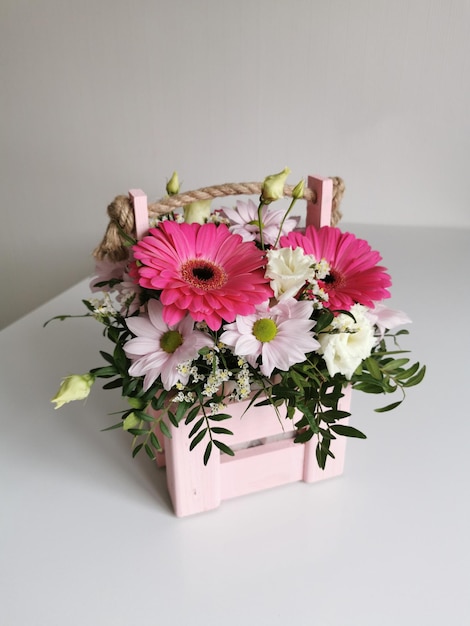 Belle boîte à fleurs rose avec gerberas eustoma chrysanthèmes pistaches gypsophile