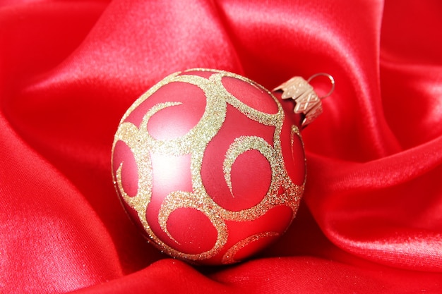 Belle boule de Noël sur tissu de satin rouge