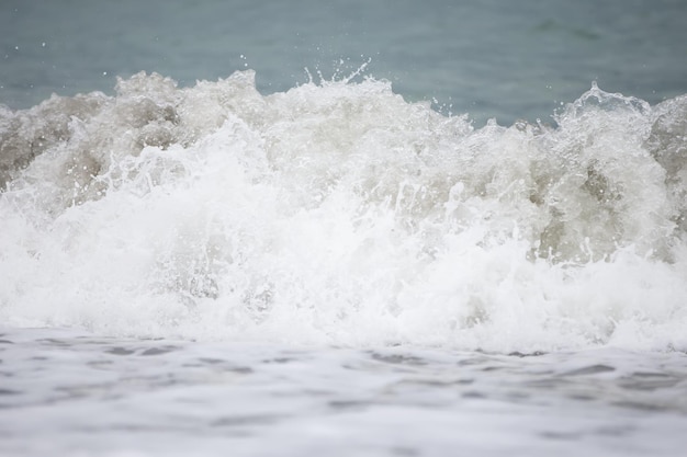 Une belle brise mousseuse des vagues de la mer en gros plan