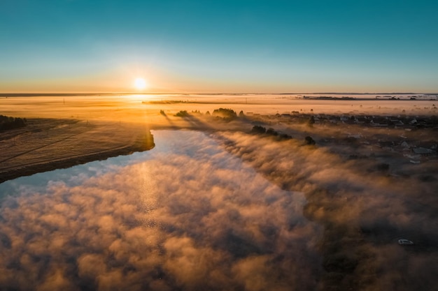 Belle brume épaisse le matin d'automne L'aube du lac contre le ciel bleu avec un soleil éclatant Biélorussie aérienne