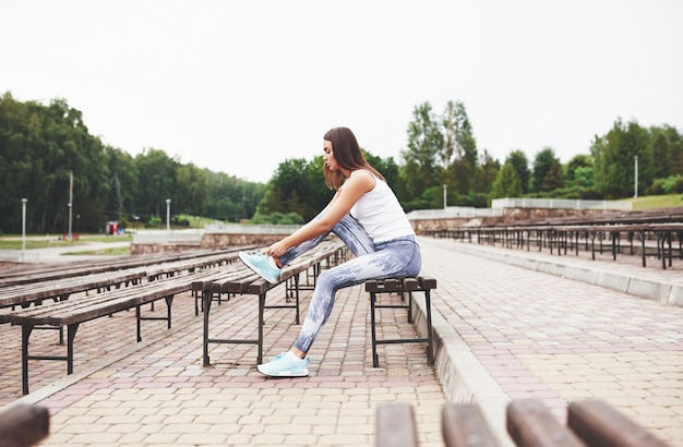 Une belle brune athlète effectue des exercices en plein air