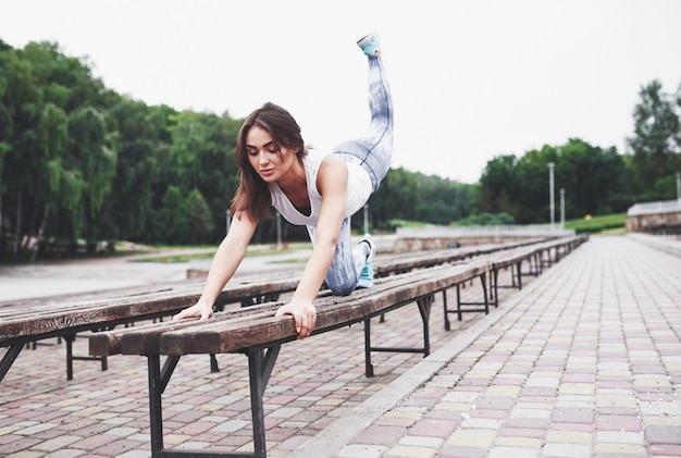 Une belle brune athlète effectue des exercices en plein air