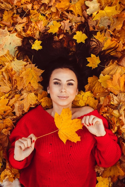 Belle brune dans la forêt d'automne avec un vélo