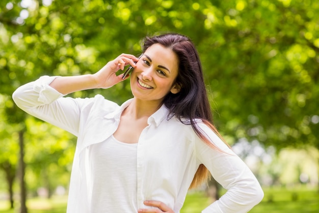 Belle brune dans le parc faisant un appel