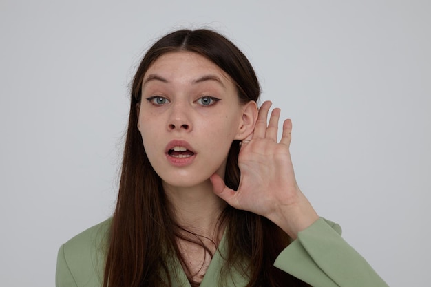 Belle brune dans des vêtements élégants posant un fond clair