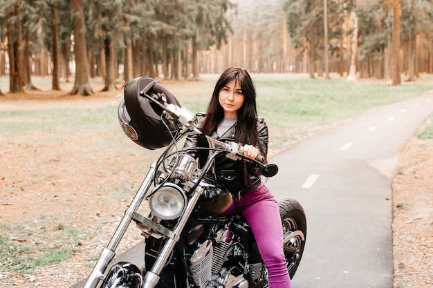 La belle brune à moto dans le parc