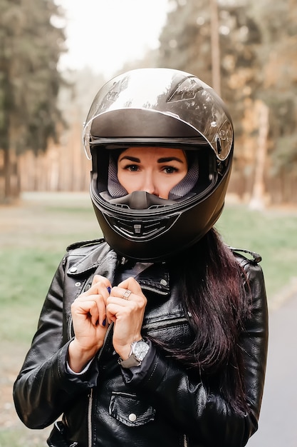 La belle brune à moto dans le parc