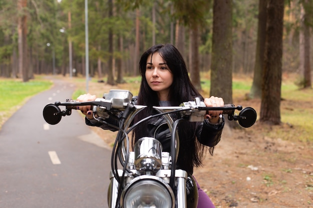 belle brune sur une moto sur piste