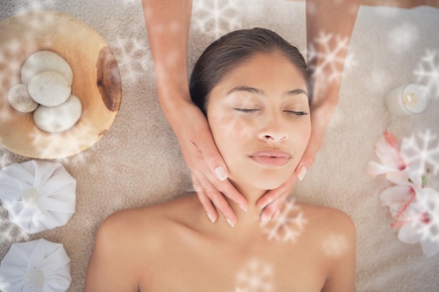 Belle brune profitant d'un massage de la tête contre les flocons de neige