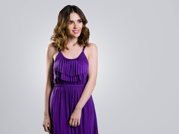 Belle brune en robe violette sur gris