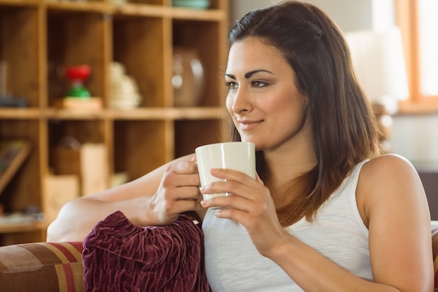 Belle brune se détendre sur le canapé