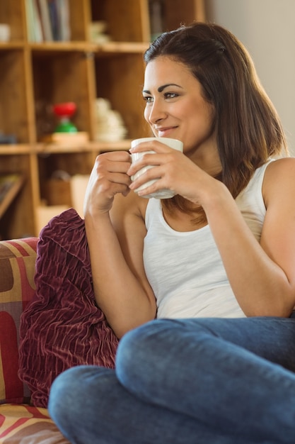 Belle brune se détendre sur le canapé