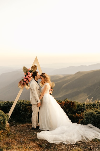 Belle cérémonie de mariage dans les montagnes, couple de mariage amoureux se tenir la main et sourire.