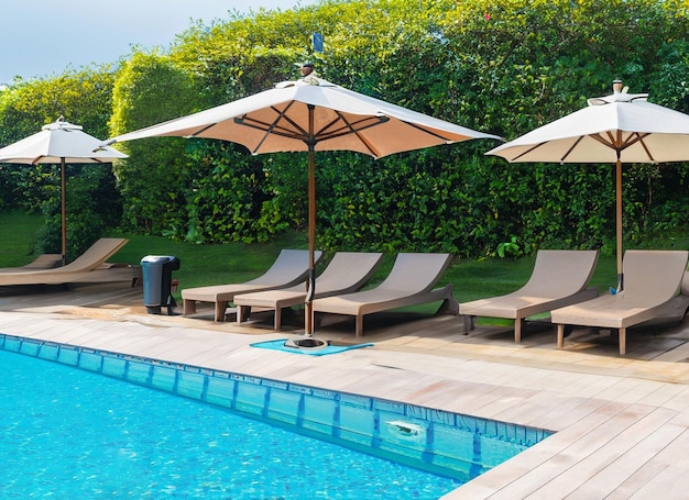 Belle chaise vide avec parasol autour de la piscine extérieure du complexe hôtelier pour les vacances