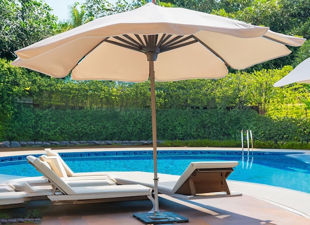 Belle chaise vide avec parasol autour de la piscine extérieure du complexe hôtelier pour les vacances