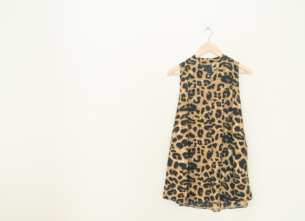 belle chemise à imprimé léopard suspendue avec un cintre en bois au mur