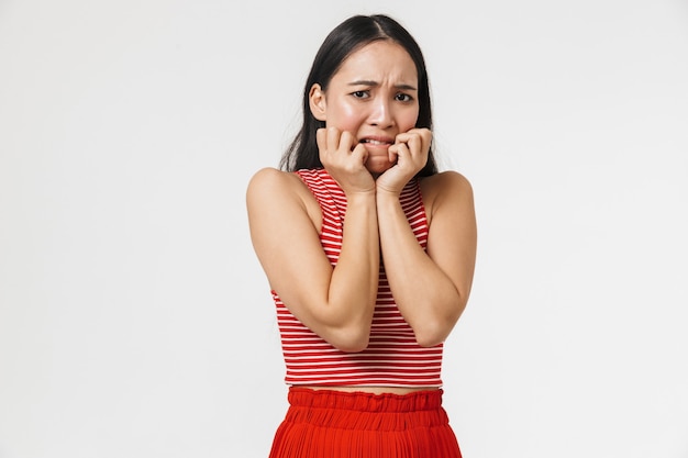 belle choquée effrayée jeune jolie femme asiatique posant isolée sur mur blanc.