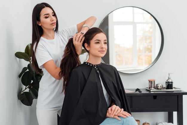 Belle coiffeuse faisant la coiffure à son client