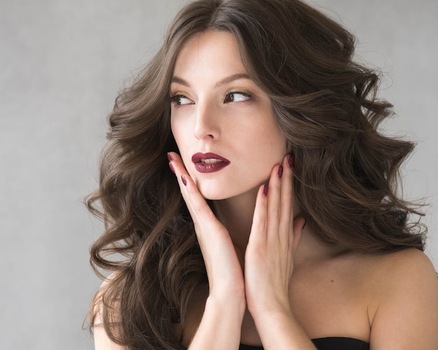 Belle coiffure femme beauté cheveux mode maquillage rouge à lèvres rouge. Prise de vue en studio.