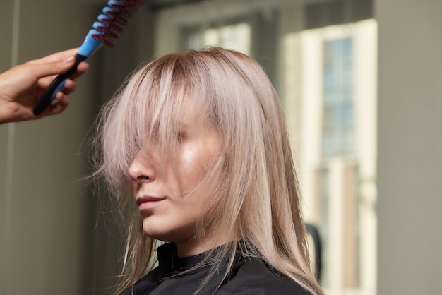 Belle coiffure de jeune femme après avoir teint les cheveux et fait des mèches dans un salon de coiffure