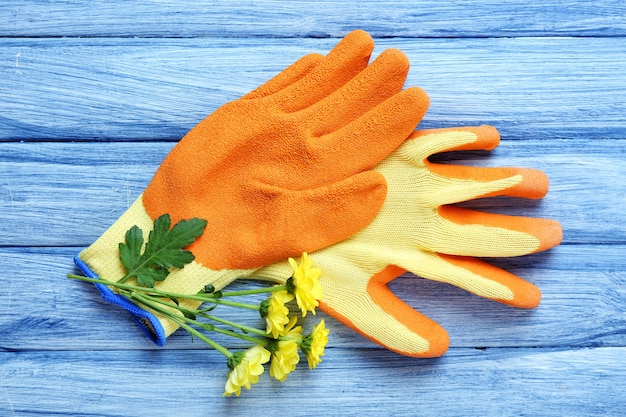 Belle composition de gants de fleurs et de jardin sur une table en bois bleue