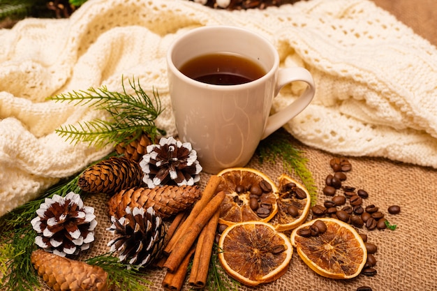 Belle composition de noël élégante avec une tasse de thé à la cannelle et des pommes de pin