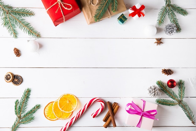 Belle composition de Noël sur fond blanc en bois avec coffrets cadeaux de Noël, fruits secs, décoration de vacances, bâton de caramel. Nouvel An.