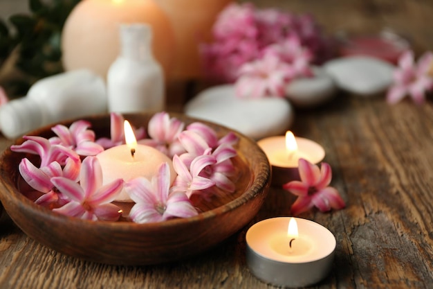 Belle composition de spa avec des fleurs et des bougies sur fond de bois