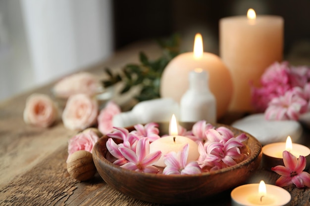 Belle composition de spa avec des fleurs et des bougies sur une table en bois