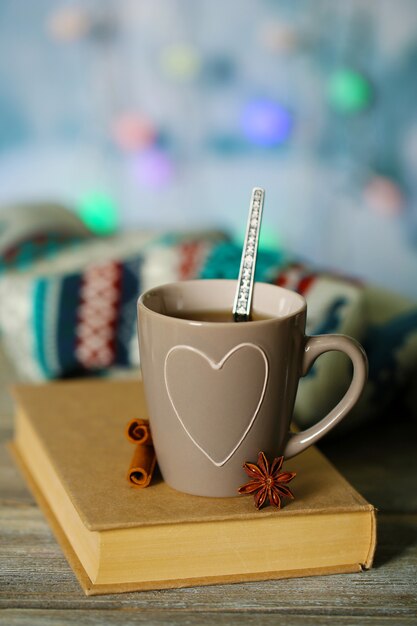 Belle composition avec tasse de boisson chaude, sur fond de lumières