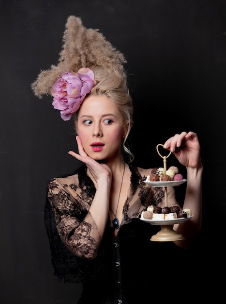 Belle comtesse blonde avec des bonbons au chocolat
