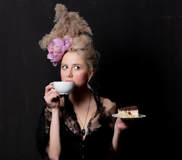 Belle comtesse blonde avec gâteau et tasse