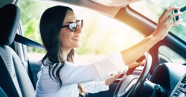 La belle conductrice ajuste le rétroviseur dans la voiture