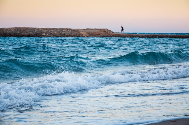 Belle côte de la mer le soir et figure solitaire d'un homme au loin. Hurghada, Egypte. Mise au point sélective