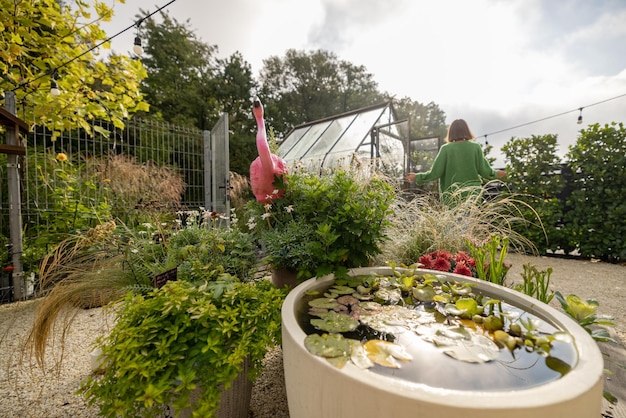 Belle cour verte avec une femme jardinant