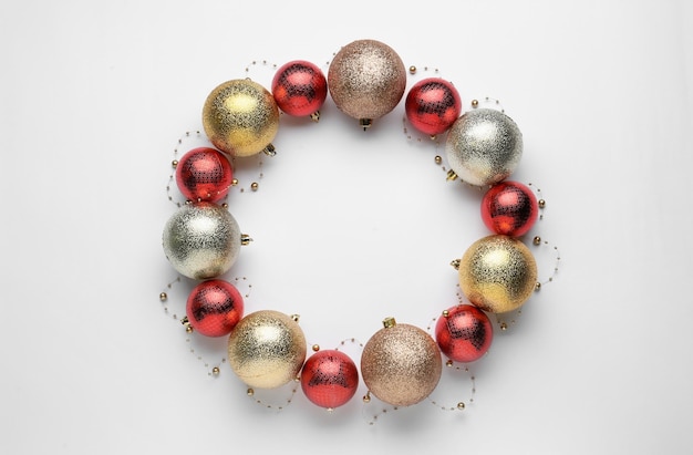 Belle couronne festive faite de boules de Noël de couleur sur la vue de dessus de fond blanc