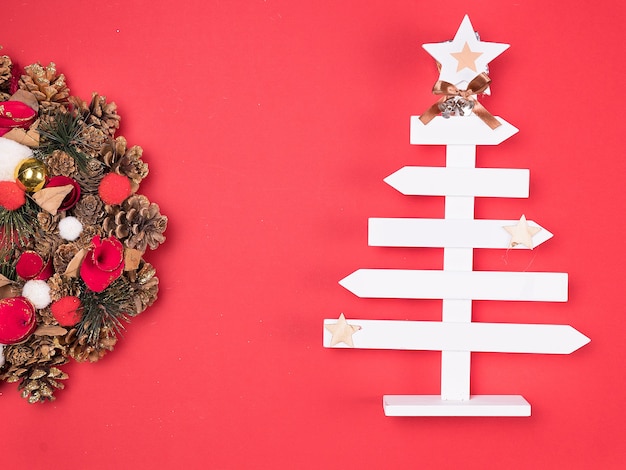 Belle couronne de Noël avec une belle décoration de la maison sur fond rouge. Décoration intérieure festive