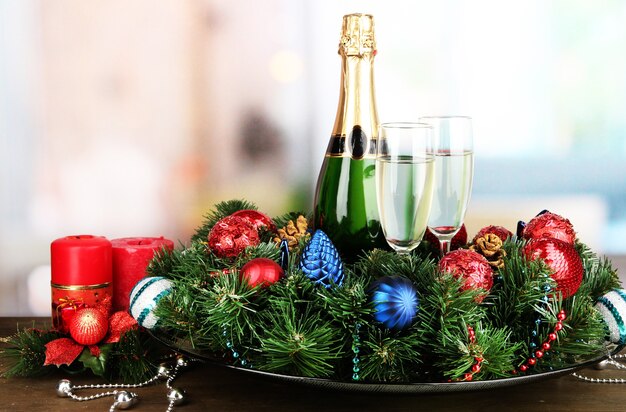 Belle couronne de Noël en composition avec champagne sur fond de chambre