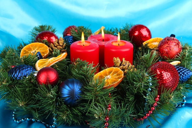 Belle couronne de Noël sur fond de tissu bleu