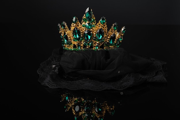 Photo belle couronne, ornement de tête féminin avec pierres vertes sur fond noir avec reflet