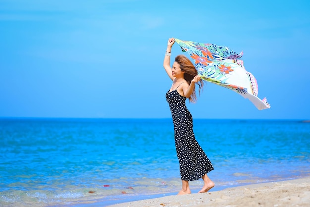 Belle dame asiatique jouant avec le concept de vacances d'été de couverture de plage