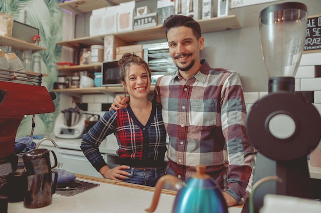 Belle dame et homme portant une chemise à carreaux debout dans un café au bar