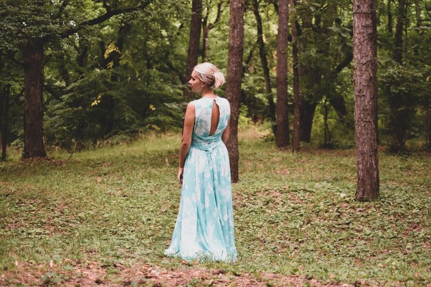 belle dame marche dans la forêt seule une femme vêtue d'une longue robe légère