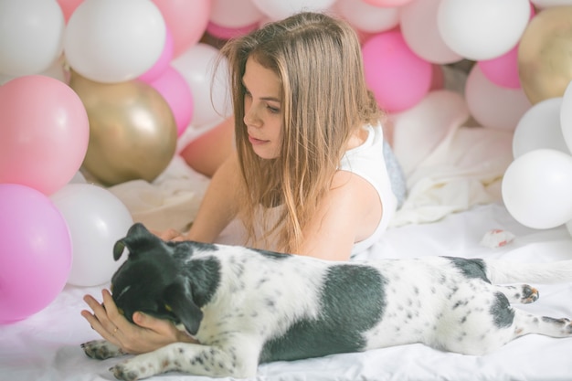 Belle dame en pyjama dans la chambre joue avec son chien