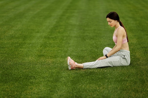 Belle dame sportive faisant des étirements au stade pratique la flexibilité de l'entraînement de femme athlétique