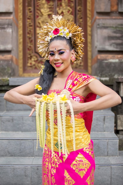 Une belle danseuse balinaise avec des fleurs de frangipani