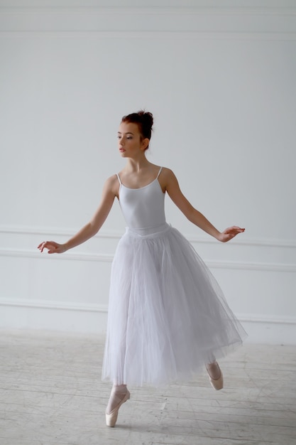 Belle danseuse de ballet dans une salle blanche