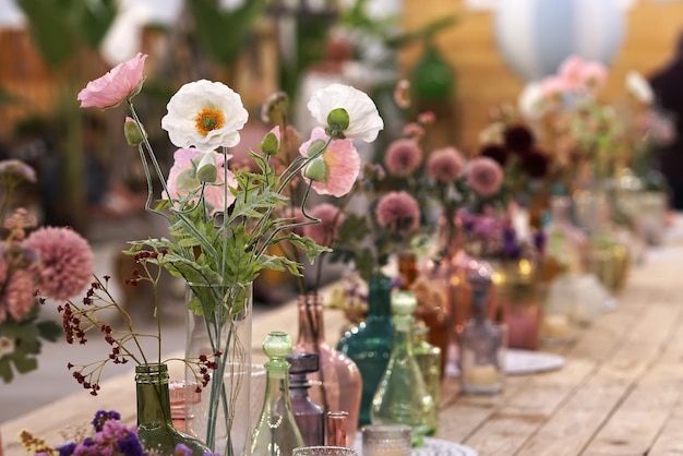 Belle décoration avec des fleurs et des vases en verre colorés