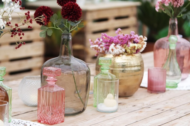 Belle décoration avec des fleurs et des vases en verre colorés