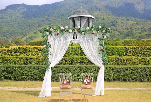 Photo belle décoration de mariage avec des chaises vous et moi dans la nature en plein air.